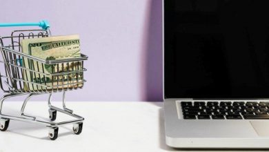 cart full of money alongside a laptop