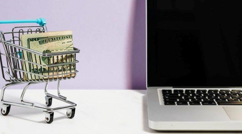 cart full of money alongside a laptop