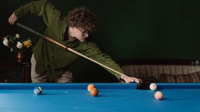 A guy playing snooker