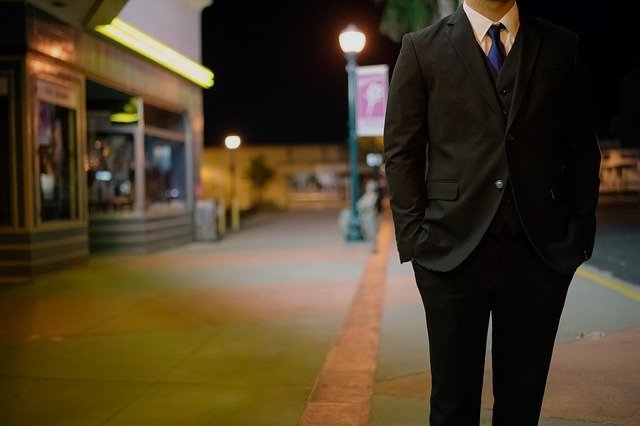 A man wearing a suit standing in a street