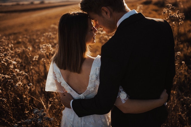 A married about to get married hugging each other from behind