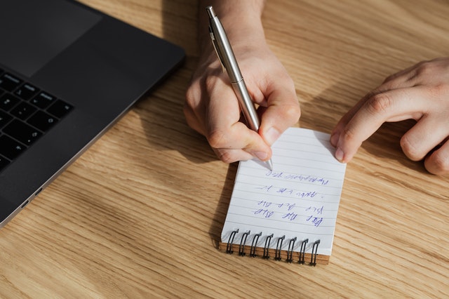 A guy writing something on a paper