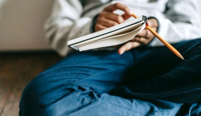 A guy writing something on a copy