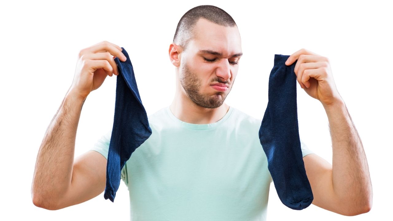 A man showing smelly socks with bad odour