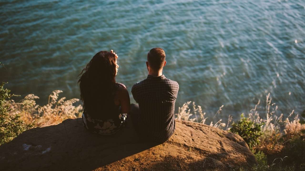 A couple in a good relationship sitting ashore a lake