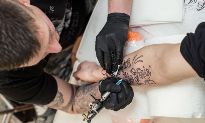 A guy getting a tattoo on forearm