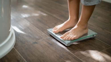 Boy checking his weight on weight scale