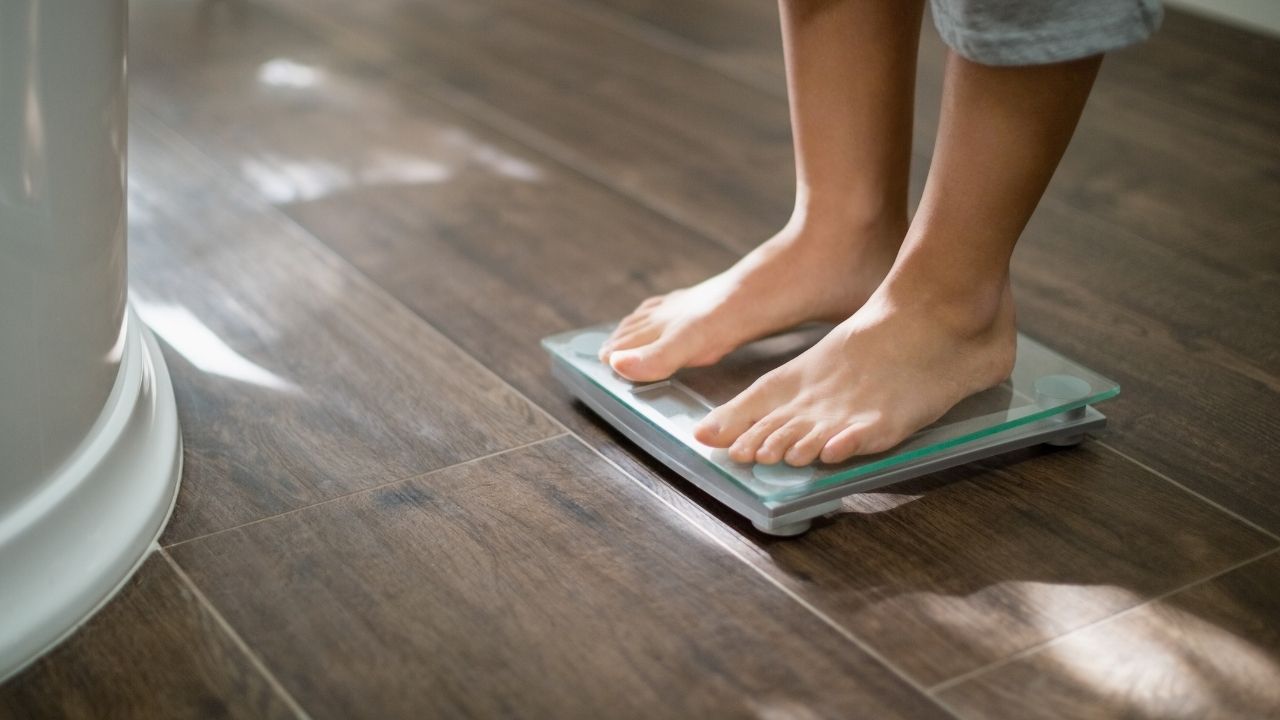 Boy checking his weight on weight scale