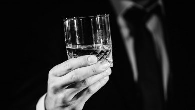 Glass of alcohol in hands of a man