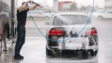 man cleaning old car