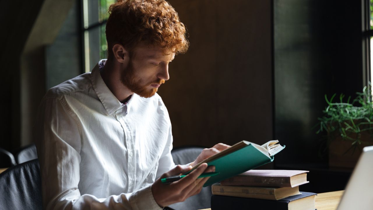 guy reading book at home