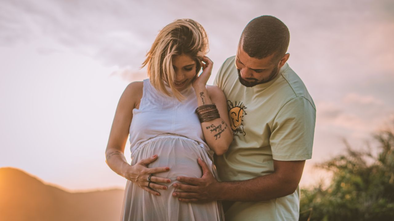 A man touching pregnant woman belly