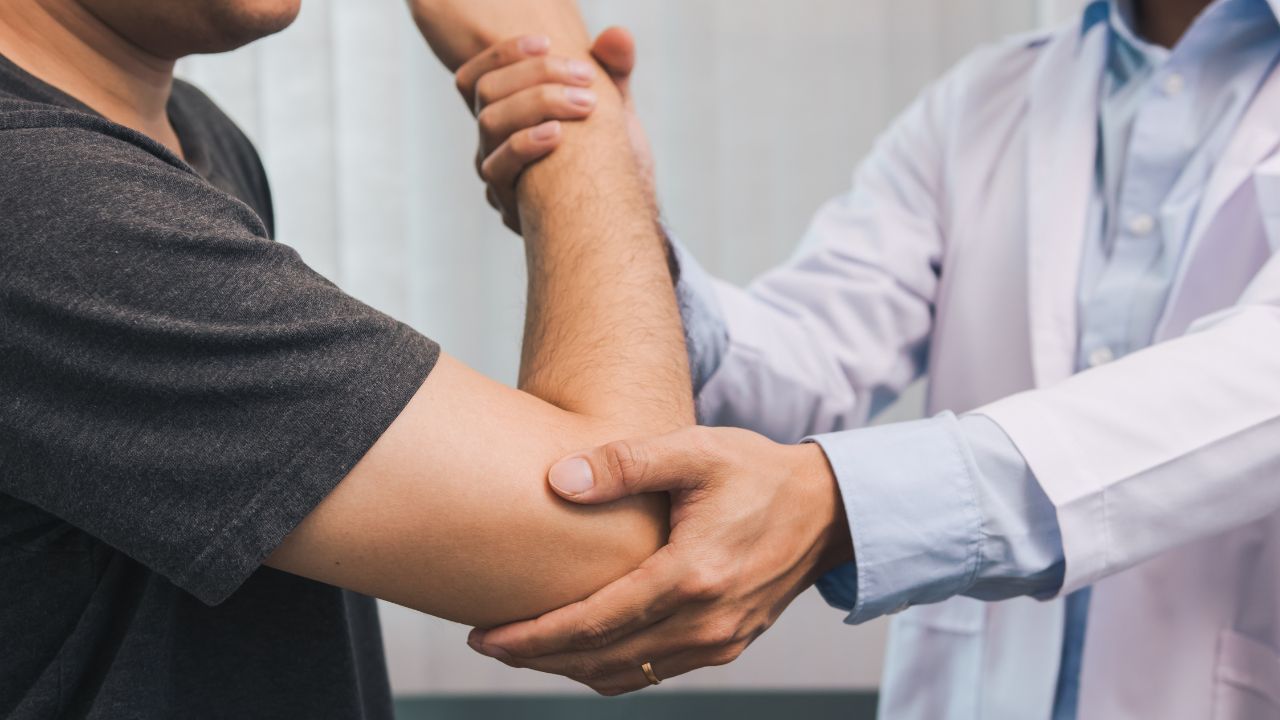 doctor checking a patients elbow