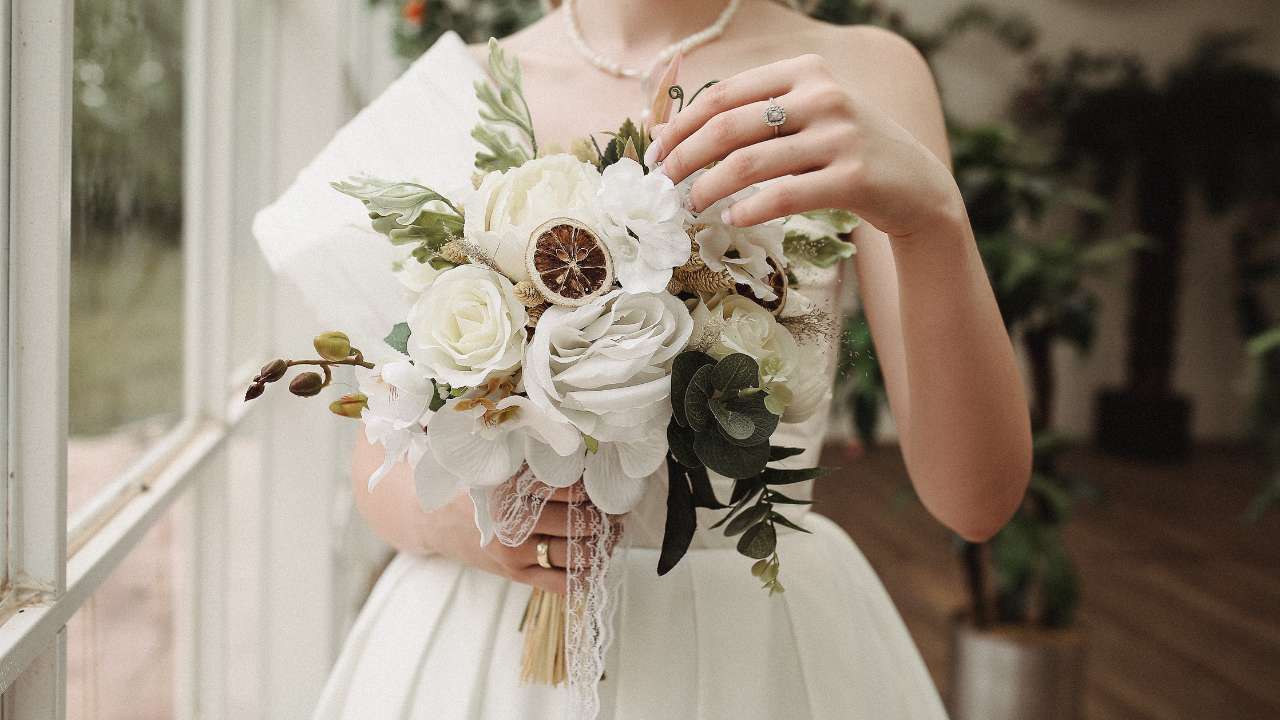 A bride admiring her stunning wedding dress, carefully planning the perfect look for her special day