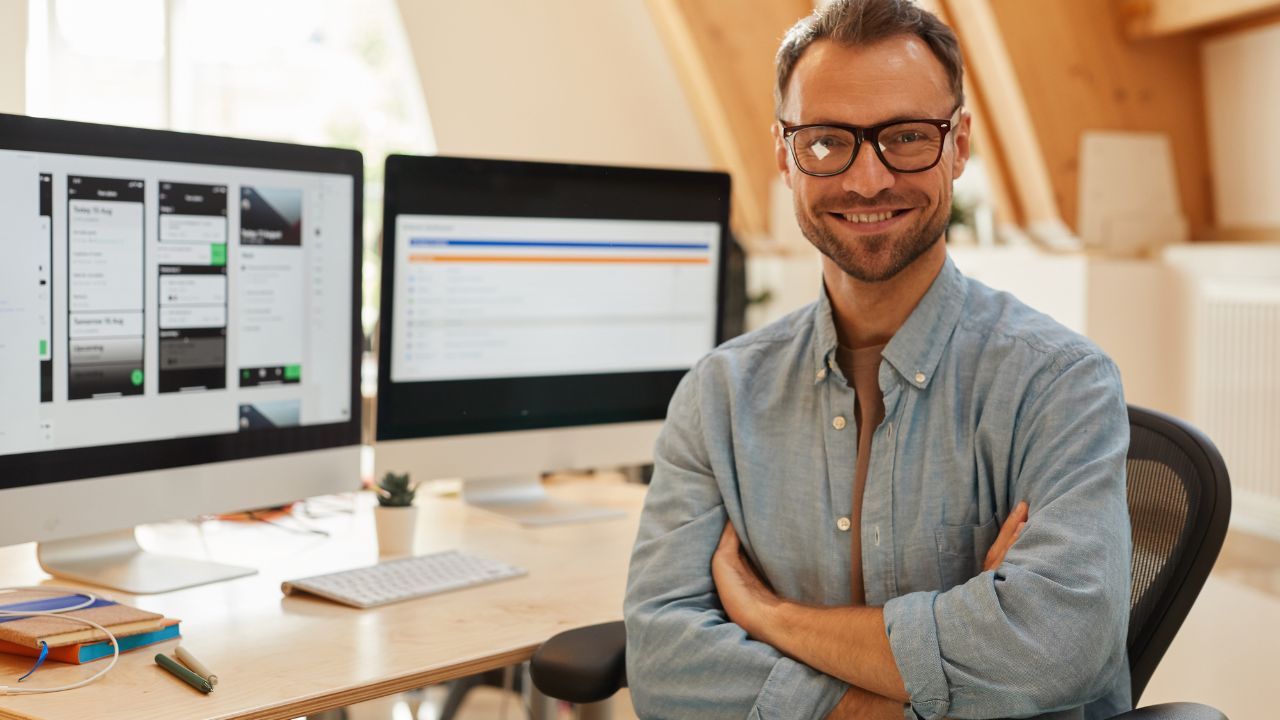 guy smiling while using free open source software on his computers