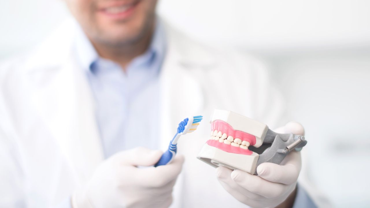 doctor brushing dummy teeth