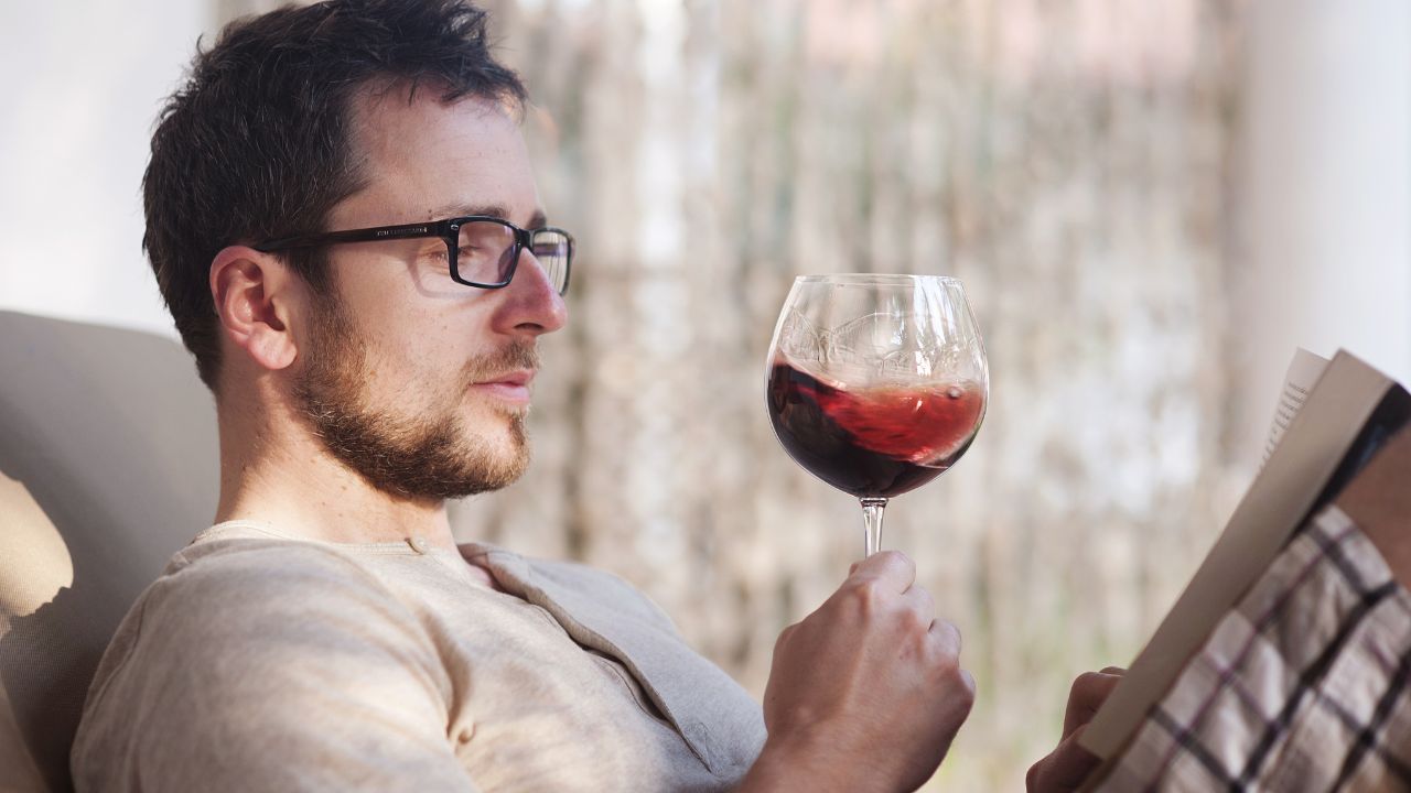 guy looking at wine glass