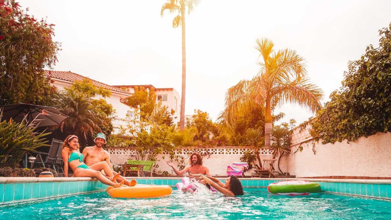 people having fun in their backyard swimming pool